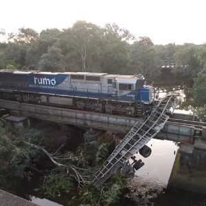 Carreta fica pendurada em ponte após colisão com trem